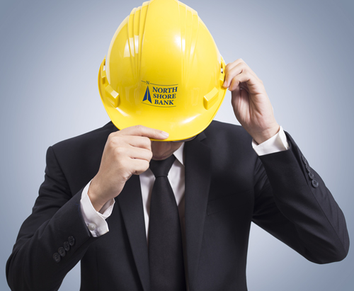 Image of business lender putting on a North Shore Bank hard hat