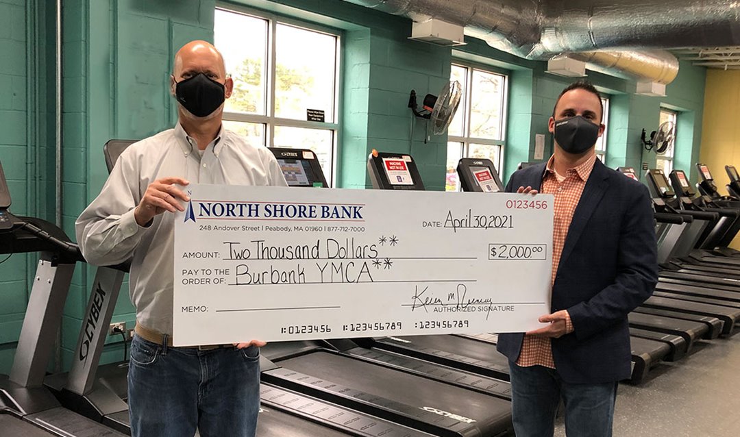 Photo of Tom Seyffert, North Shoer Bank Branch Manager presenting a $2,000 Jeans Day donation to the Burbank YMCA.  