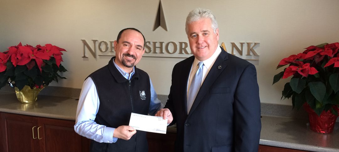 Andrew DeFranza (left), Executive Director of Harborlight Community Partners, receives a $20,000 donation from Kevin Tierney, Sr., President and CEO of North Shore Bank