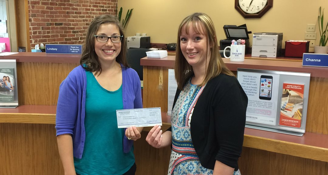 Kathleen Philp of the Merrimac Playground Committee receiving a $1,500 donation from North Shore Bank’s Aimee Martin