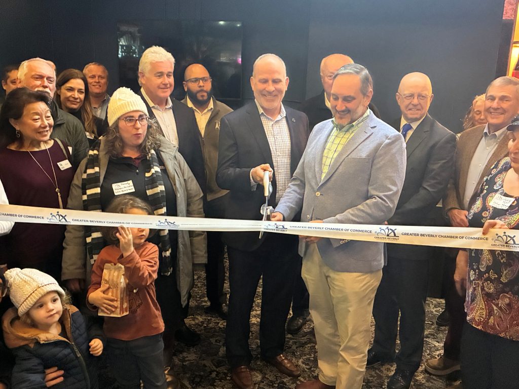 A man cutting a ribbon at the Cabot Performing Arts Center to Sponsor New Stageside Lounge.